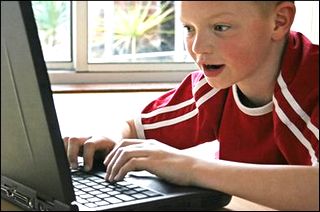 Boy in Red T-shirt using the Computer Boy in Red T-shirt using the Computer